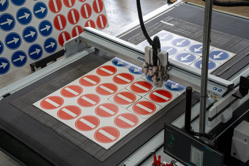 Snijtafel met vellen vol pictogrammen in de eigen productiehal