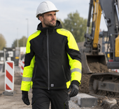 Reflecterende winterjas werkjas ripstop Tricorp 406117 zwart fluorgeel, gedragen op de bouwplaats